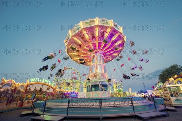 Radiant carousel under the night sky at a funfair, chain carousel, spring festival, Cannstatter Wellenflug, illuminated, blue hour, Cannstatter Wasen, Bad Cannstatt, Stuttgart, Baden-Württemberg, Germany