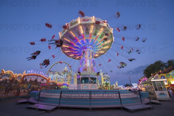 Colourful, illuminated carousel at night at a funfair, chain carousel, spring festival, Cannstatter Wellenflug, illuminated, blue hour, Cannstatter Wasen, Bad Cannstatt, Stuttgart, Baden-Württemberg, Germany