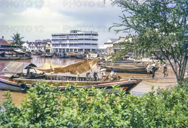 Unloading sacks from cargo boat on Singapore River, Singapore, southeast Asia c 1963 Sime Darby Ltd Godown warehouse in background