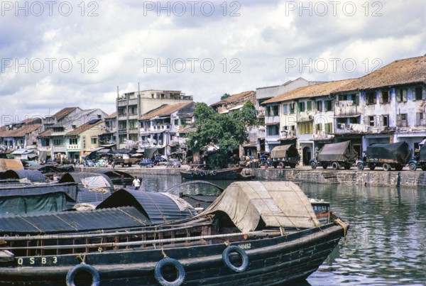 Port activity, boats and vehicles waterfront of Singapore River, Singapore, southeast Asia c 1963