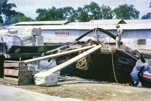 Loading rubber bales onto boat, Singapore River, Singapore, southeast Asia c 1963 Tong Fong Co Ltd Store warehouse in background