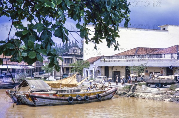 Unloading sacks from cargo boat on Singapore River, Singapore, southeast Asia c 1963