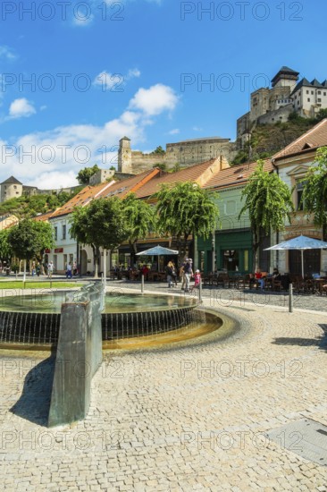 Mark Aurel fountain and fountain on Peace Square with Trencin Castle in the background, Capital of Culture 2026, Trencín, Slovakia