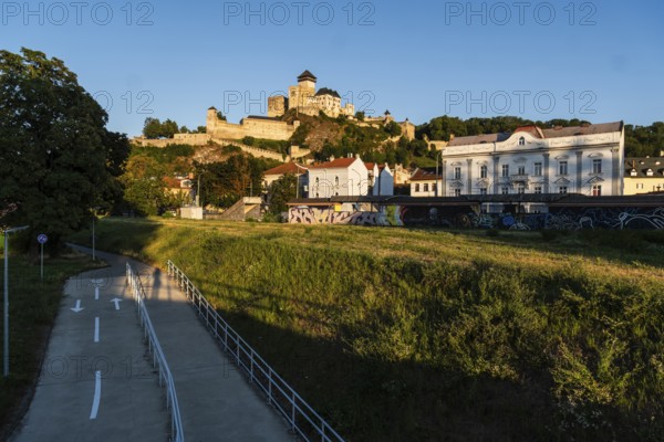 View of the castle and town of Trencín from the riverbank in the evening light, Capital of Culture 2026, Trencín, Slovakia
