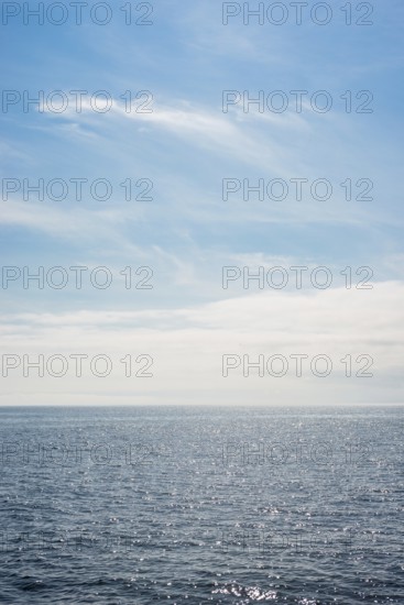 Dark ocean under a clear blue sky with bright white feathery clouds, cloud bank, horizon, water with light reflections, dark blue, light, reflection, sunny, water surface, summer, sunny, weather, calm sea, vastness, horizon, landscape, maritime, nature, relaxation, recreation, sunlight, freedom, sea voyage, too: threatening emptiness, being lost, infinite, infinity, nobody, alone, loneliness, journey with the Halunderjet from Heligoland to Hamburg, German Bight, North Sea, Germany