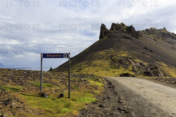 Gravel road with sign for place of interest, lava cave, Sönghellir lava tube, Stapafell mountain, Arnarstapi, Snaefellsjökull National Park, Snaefellsnes Peninsula, West Iceland, Iceland