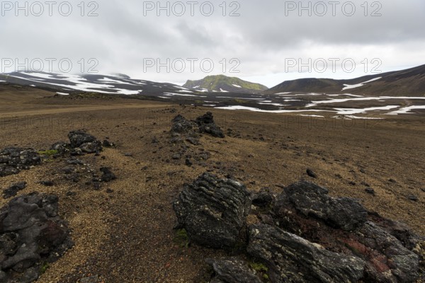 Barren volcanic landscape with snow fields, volcanic rock, mountain peaks with rain clouds, Snaefellsjökull, Snæfellsnes peninsula, Snaefellsnes, West Iceland, Iceland