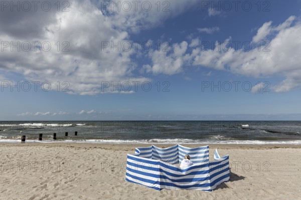 Deserted beach with person behind windbreak, blue sky, Baltic Sea near Kühlungsborn, Mecklenburg-Western Pomerania, Germany