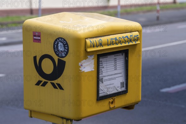 Deutsche Post letterbox, with stickers and graffiti, labelled Only love letters, Leverkusen, North Rhine-Westphalia, Germany