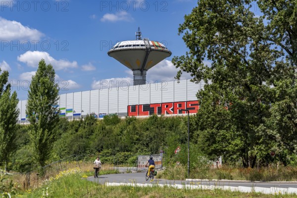 Green corridor with the river Dhünn, 40 km long river that flows into the Wupper near Leverkusen, renaturalised section, here shortly in front of the mouth along the A1 motorway, at the Leverkusen-West junction, noise barrier, landmark Leverkusen water tower, graffiti by the Ultras Leverkusen, North Rhine-Westphalia, Germany