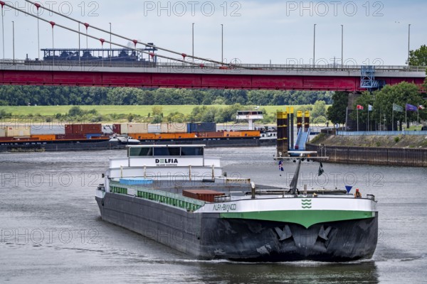 Barge enters the Vinckekanal, in the harbour of Ruhrort, container freighter on the Rhine, on an uphill journey, Friedrich-Ebert-Bridge, road bridge over the Rhine between Homberg and Ruhrort, Thyssenkrupp Steel steelworks, Duisburg, North Rhine-Westphalia, Germany