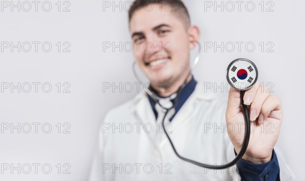 Doctor showing stethoscope with South Korea flag. South Korea national healthcare concept