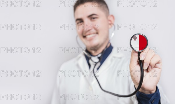 Doctor showing stethoscope with Malta flag. Malta national healthcare concept