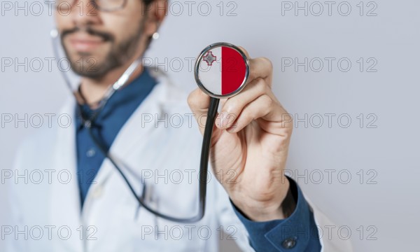 Doctor holding stethoscope with Malta flag. Malta health and care concept, Malta flag on stethoscope