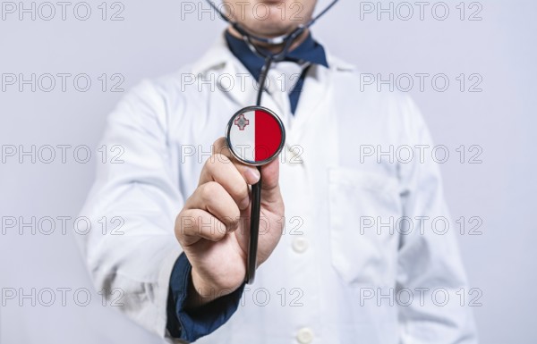 Doctor hands holding stethoscope with Malta flag. Malta health and care concept
