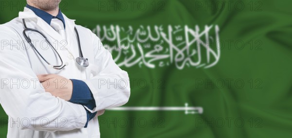Saudi Arabia healthcare concept. Male doctor on Saudi Arabia flag. Doctor with crossed arms on Saudi Arabia flag