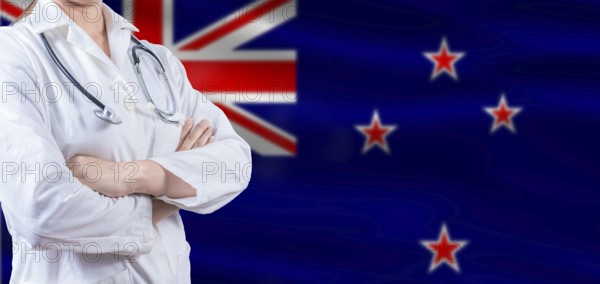 Doctor with crossed arms on New Zealand flag. New Zealand health and care concept. Female doctor on New Zealand flag