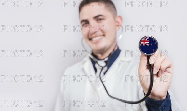 Doctor showing stethoscope with New Zealand flag. New Zealand national healthcare concept