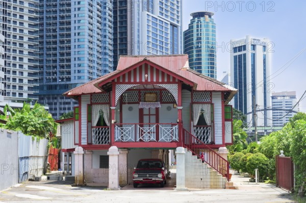 Traditional small house surrounded by modern skyscrapers, Kuala Lumpur, Malaysia, Asia