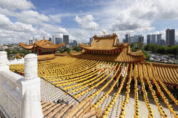 Thean Hou Temple to the Goddess Mazu with yellow chines lanterns and Kuala Lumpur skyline, Malaysia, Asia