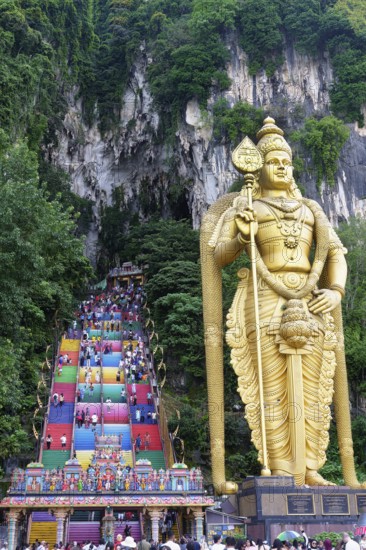 Murugan statue the God of War and colorful staircase leading to the caves with many pilgrims, Batu Caves complex, Kuala Lumpur, Malaysia, Asia