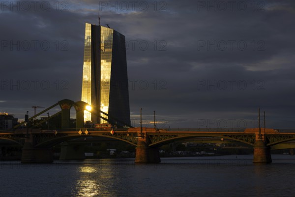 The light of the setting sun is reflected on the glass façade of the European Central Bank (ECB) in Frankfurt am Main, Frankfurt am Main, Hesse, Germany