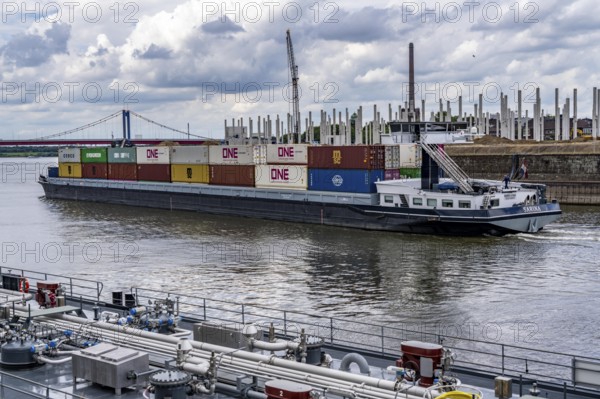 Construction of a new logistics hall on the Mercatroinsel, Hall 2, next to an existing hall, approx. 25, 000 square metres in size, in Duisburg-Ruhrort, shell construction, container freighter leaving the port canal for the Rhine, North Rhine-Westphalia, Germany