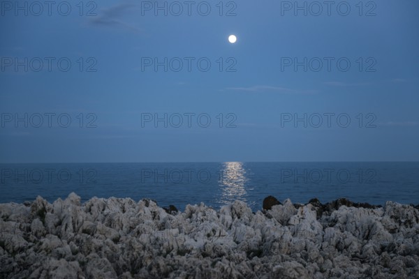 Rocks by the sea and full moon, Cap Martin, near Menton, Alpes Maritimes, Provence Alpes Cote d'Azur, French Riviera, South of France, France