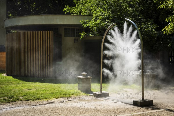 A mobile spray arch sprays fine water mist in a park in Bratislava, Slovakia