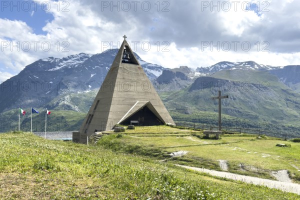 Pyramid museum in the form of a stylised pyramid as a museum commemorating the Egyptian campaigns of Emperor Napoleon Bonaparte and the time in front of the construction of the Lac du Mont Cenis reservoir, in the foreground a large free-standing Christian cross, Mont Cenis massif, Massif du Mont-Cenis, Graian Alps, Lanslebourg, Rhone-Alpes, France