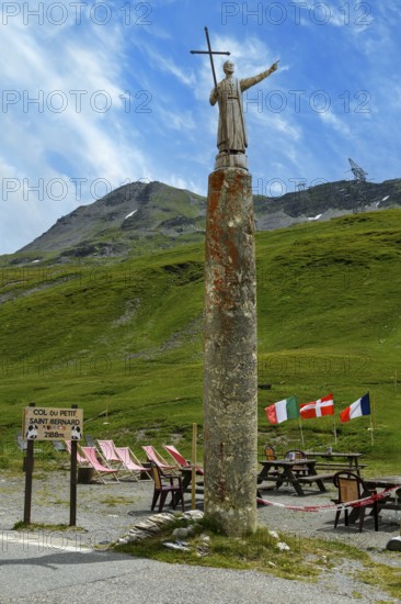 Monolith made of serpentinite historical ancient Roman so-called Jupiter column probably column of temple in antiquity with statue of Roman god Iuppiter Jupiter Giove today with figure of Saint Bernard of Menthon next to pass road on pass summit of Colle del Piccolo San Bernardo, Col du Petit Saint Bernard Little Saint Bernard Pass in Alps, Département Savoie, France