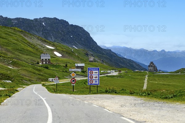 High mountain pass road above tree line with 2188 metre high alpine pass Little Saint Bernard, Colle del Piccolo San Bernardo, Col du Petit Saint Bernard, on the right in the background historical Hospice du Petit Saint Bernard, Département Savoie, France