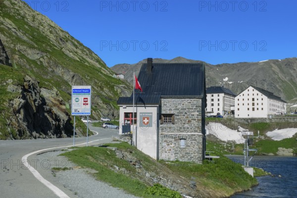View of former border building on Colle del Gran San Bernardo at border crossing from Italy to Switzerland, in the background historic Auberge Herberge Hospice on 2473 metre high pass summit of Great Saint Bernard, Saint-Rhémy-en-Bosses, Aosta Valley region, Italy
