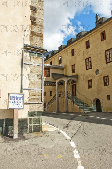 View around the corner from left Auberge de Grand Saint Bernard hostel right historic Hospice Hospice with accommodation at the top of the Alpine pass Grenzpass Großer Sankt Bernhard Pass, in between pass road to Col du Grand-Saint-Bernard Colle del Gran San Bernardo, Canton Valais, Switzerland