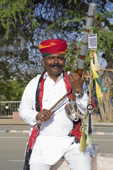 Indian man playing a long-necked spit lute or Ravanahattha, Udaipur, Rajasthan, India