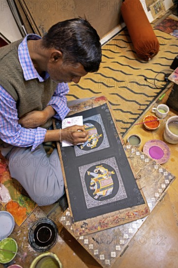 Miniature painter, 52 years old, paints an elephant picture in his studio, Udaipur, Rajasthan, India