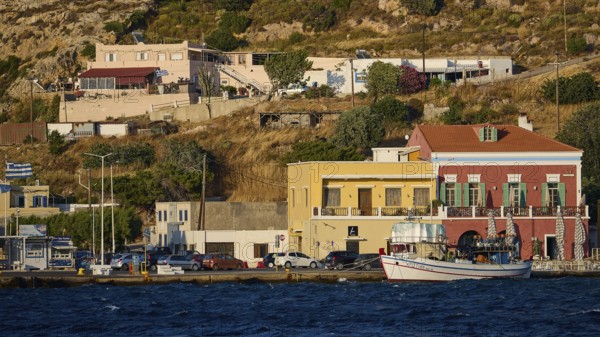 Buildings and boats along the coastline with hills in the background in sunny weather, Agia Marina, Leros, Dodecanese, Greek Islands, Greece