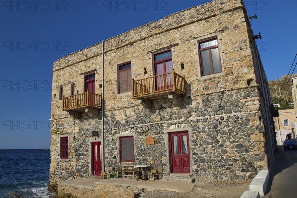 Two-storey stone house with red windows right by the sea, rustic charm, Agia Marina, Leros, Dodecanese, Greek Islands, Greece