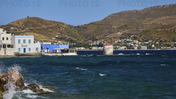 View of a coastal landscape with windmill, blue water and houses in front of hills, Agia Marina, Leros, Dodecanese, Greek Islands, Greece