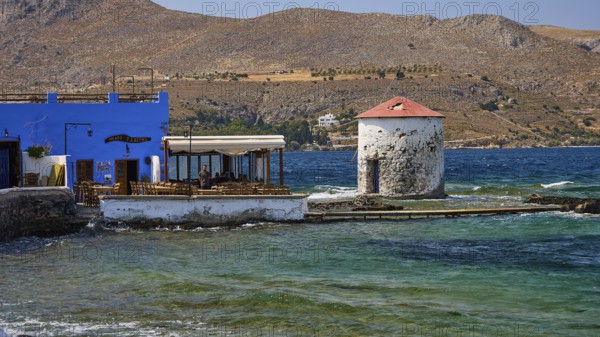 Restaurant Mylos, coastal village with windmill and blue buildings in front of mountain landscape, Agia Marina, Leros, Dodecanese, Greek Islands, Greece
