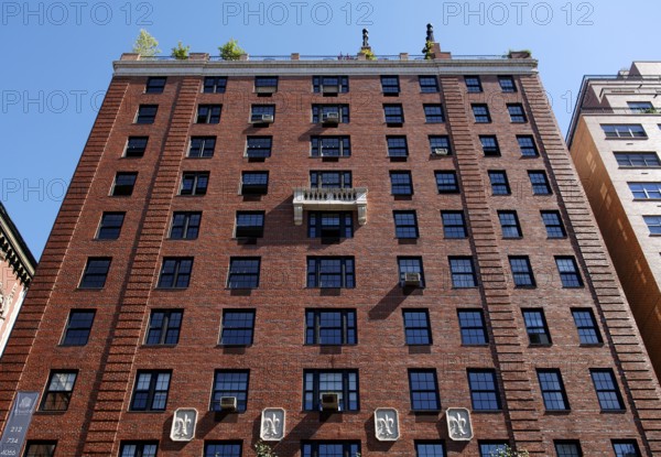 Facade of a brick apartment block with a white stone balcony, New York City, USA