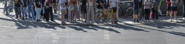 Passers-by waiting at a pedestrian crossing, Munich, Bavaria, Germany