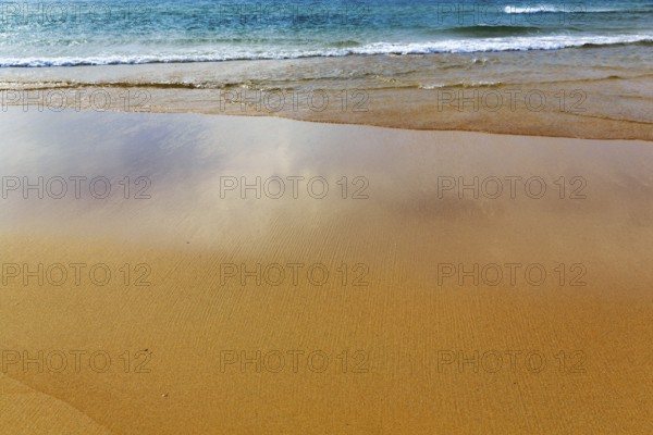 Orange-red lonely beach Raudisandur, fine structures in the sand, turquoise blue sea, Rauðisandur, coastline near Patreksfjördur, Vestfirðir, Westfjords, Iceland