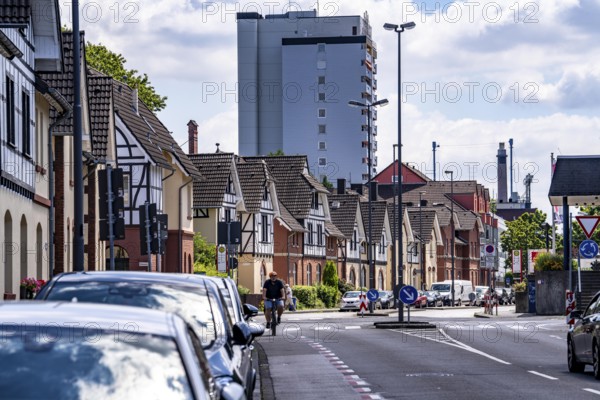 Residential buildings, on Nobelstrasse, in the Wiesdorf district, in Leverkusen, Bayer AG's Plant Estate II, heritage-protected building, in the background residential tower block and Bayer Cross in Chempark Leverkusen, North Rhine-Westphalia, Germany