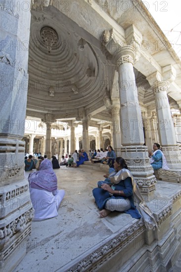 Indian woman praying between the white marble pillars in the Adinath temple in Ranakpur, Jain temple, Rajasthan, India