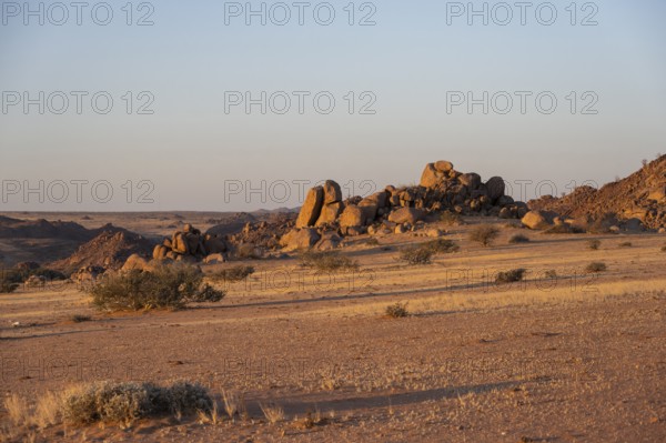 Barren landscape with hills of stacked rocks, desert landscape in the evening light at sunset, Erongo, Damaraland, Namibia