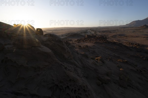 Eroded rock formations at sunrise with sun star, Erongo, Damaraland, Namibia