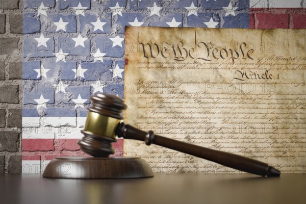 United states constitution and american flag on wall with gavel resting on table in front