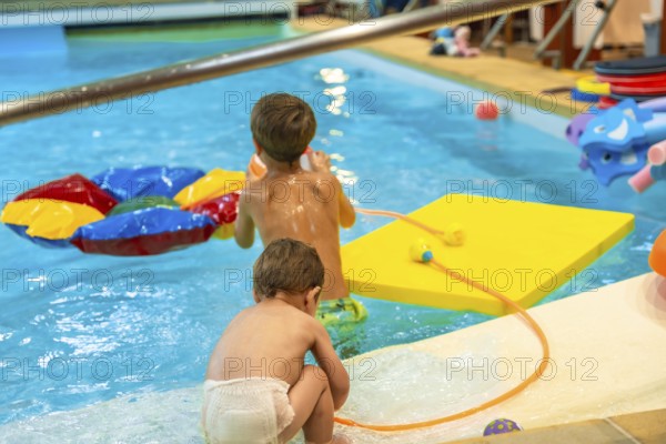 Two brothers enjoying playful moments with inflatable toys in a swimming pool, embracing the joy of summer holidays and carefree fun