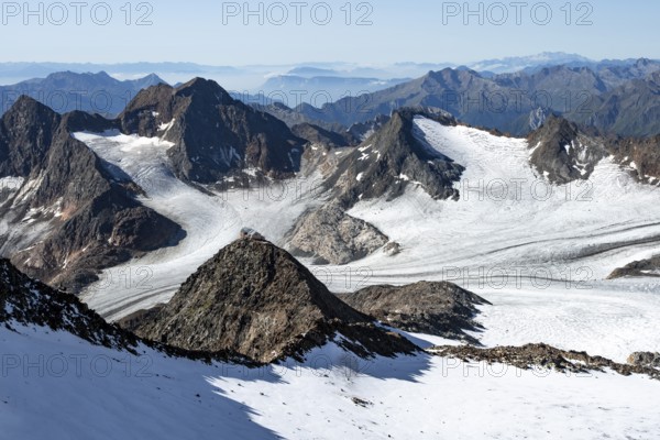 At the Wilder Freiger summit, picturesque high mountain landscape with snow, view of the Übeltalferner glacier and rocky mountain peaks Becher with Becherhaus and Königshofspitz, Stubai Alps, South Tyrol, Italy